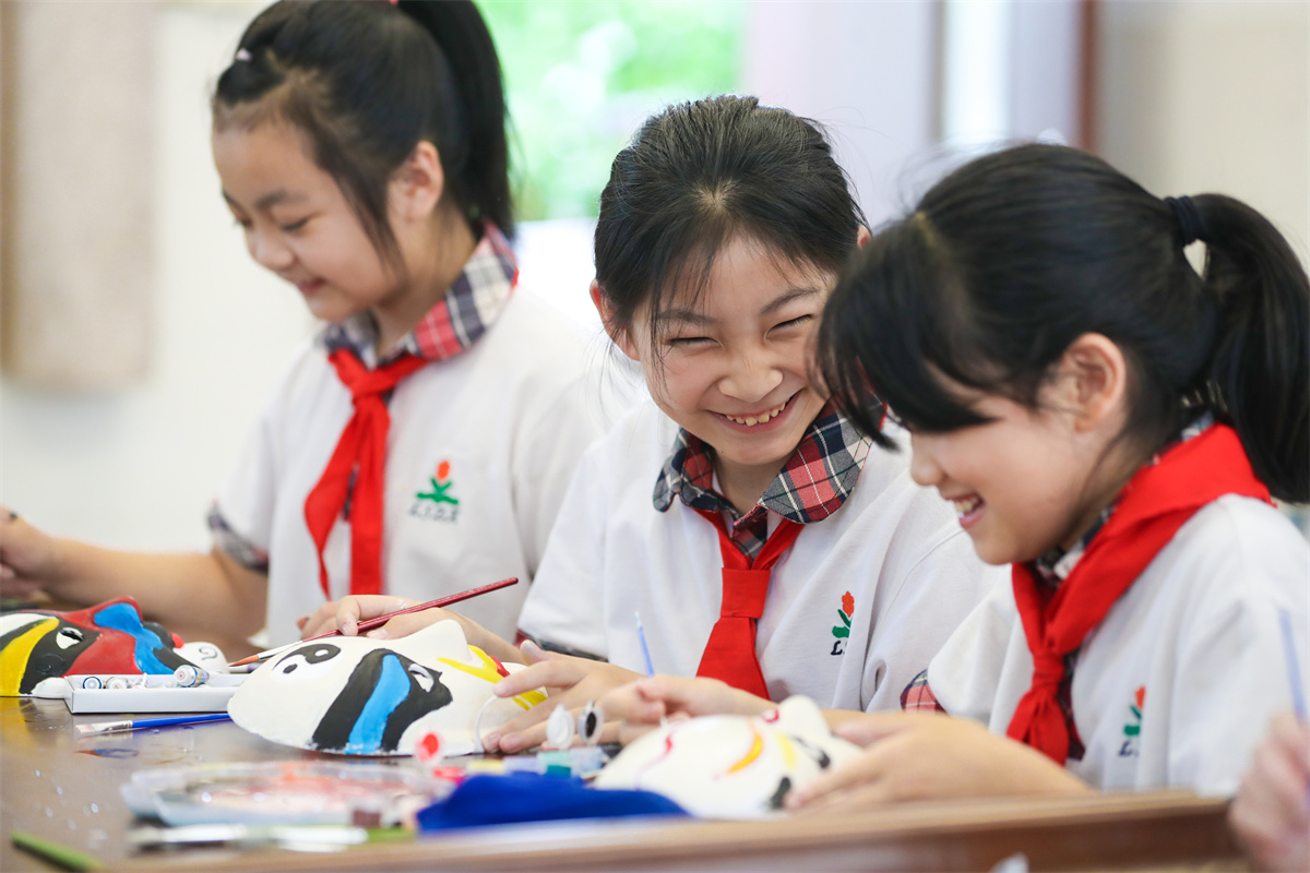 Students from a primary and middle school in Luoshe County, Huzhou City, east China's Zhejiang Province, paint Peking Opera face masks in class, June 8, 2023. /CNSPHOTO