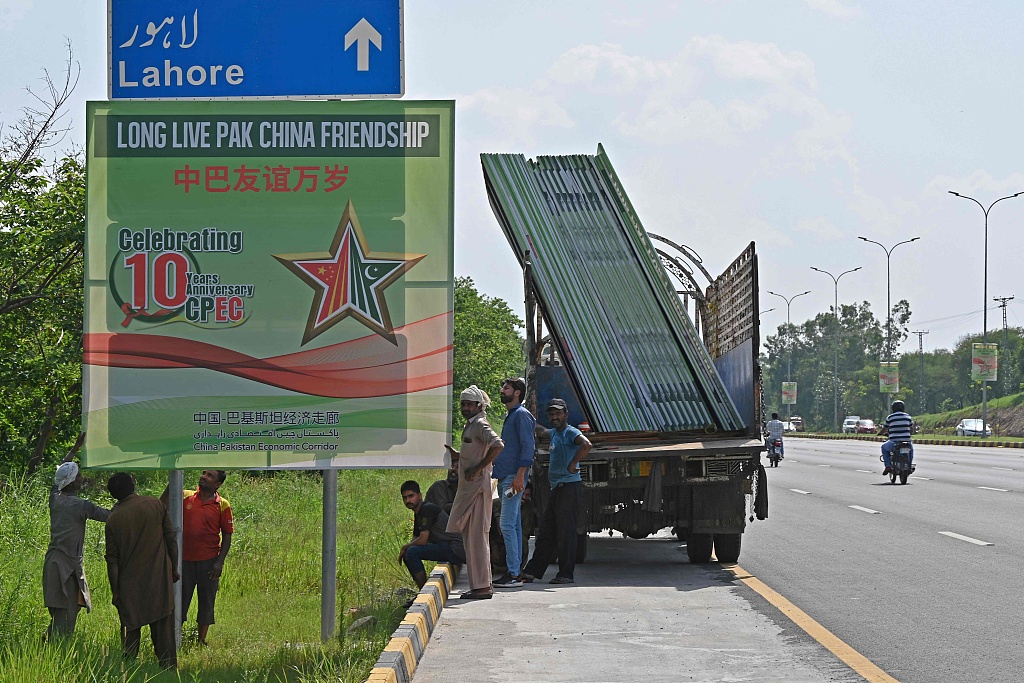 Workers install billboards along a roadside, Islamabad, Pakistan, July 30, 2023. /CFP