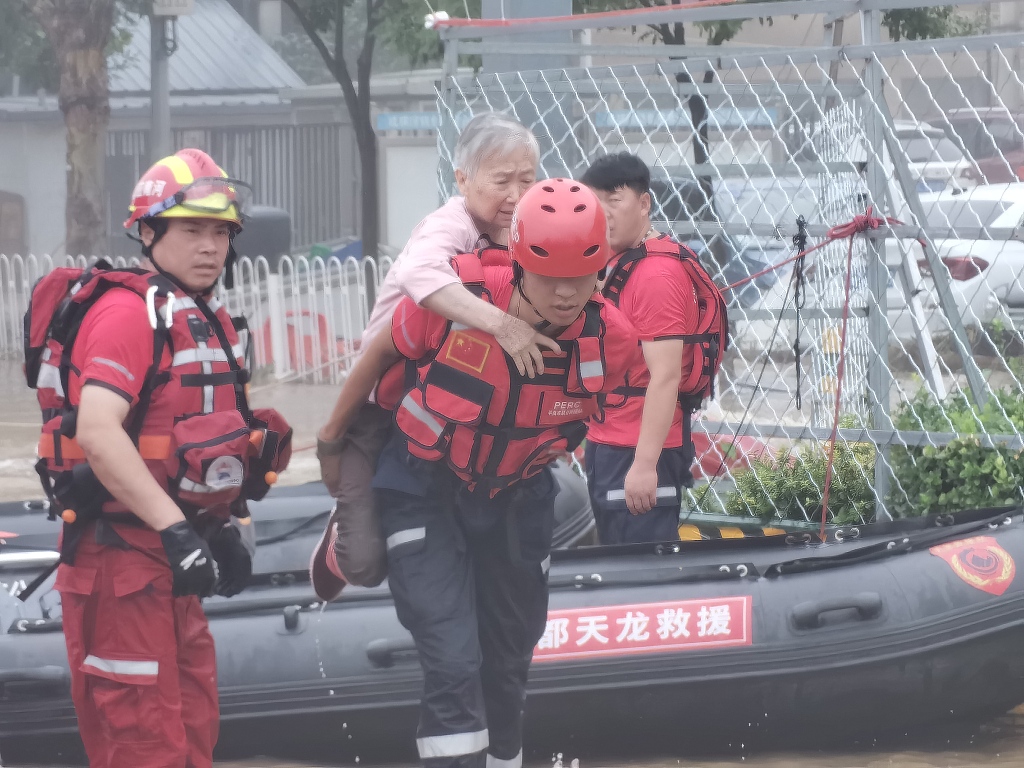  Service members of the People's Armed Police rescue elderly people trapped by flood in Beijing's Fangshan District on August 1, 2023. /CFP
