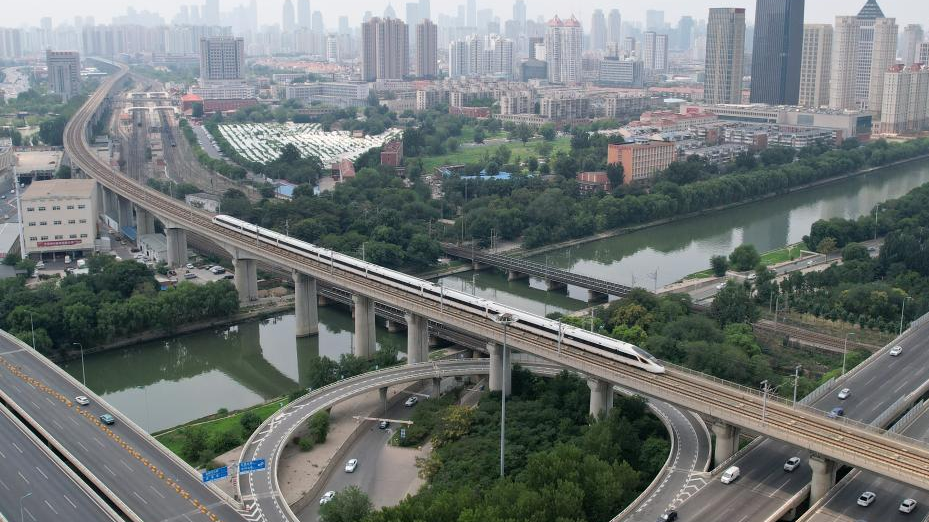 This aerial photo shows a train operating on the Beijing-Tianjin Intercity Railway in the urban area of north China's Tianjin Municipality, July 20, 2023. /Xinhua