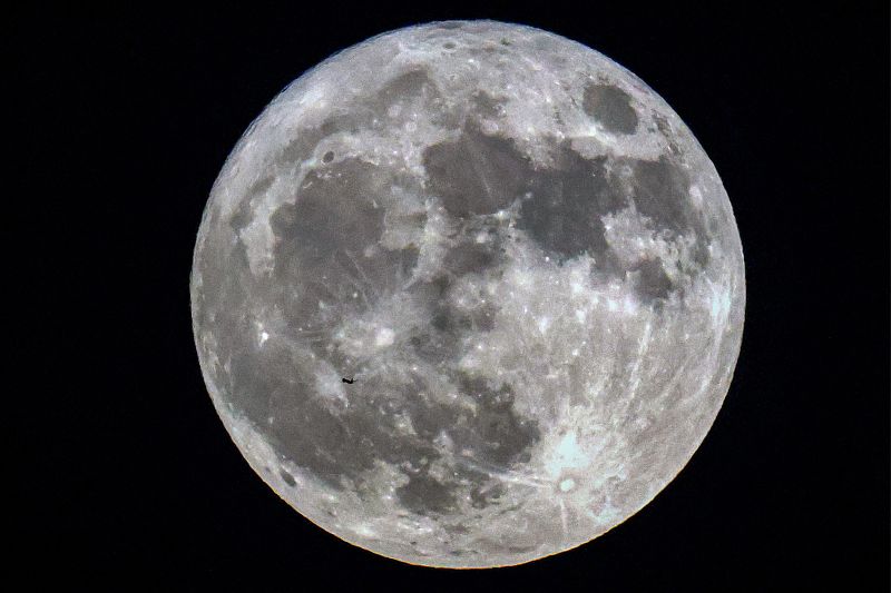 A commercial airline aircraft flies before the rising supermoon above Kuwait City, Kuwait, August 1, 2023. /CFP