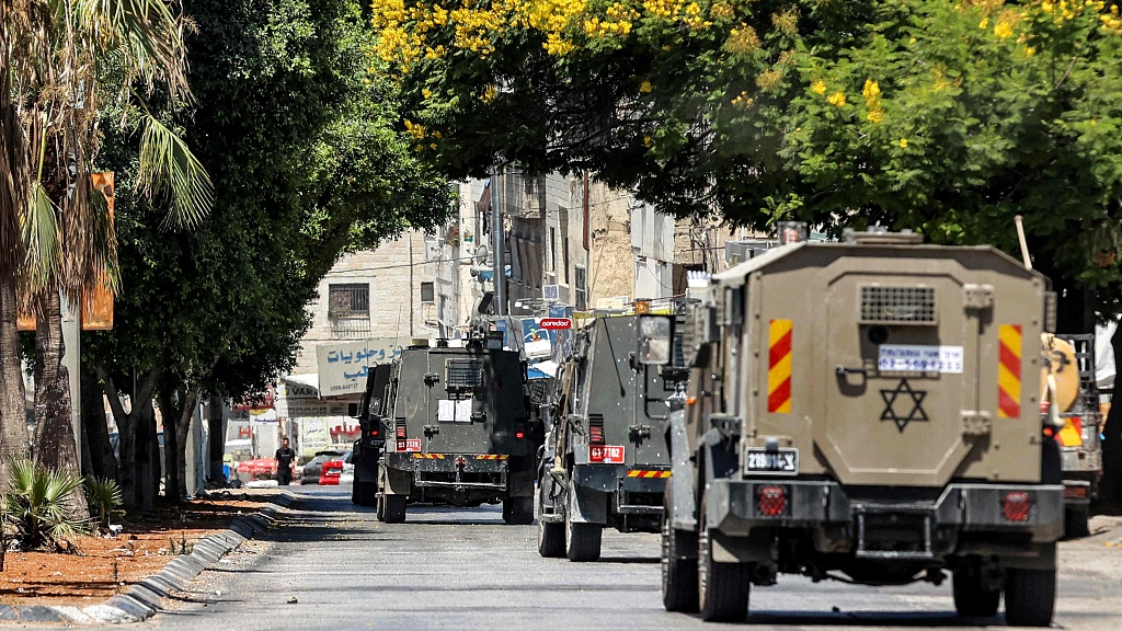 Israeli army vehicles move along a road during an army raid in al-Ain camp for Palestinian refugees, west of Nablus in the occupied West Bank, July 26, 2023. /CFP