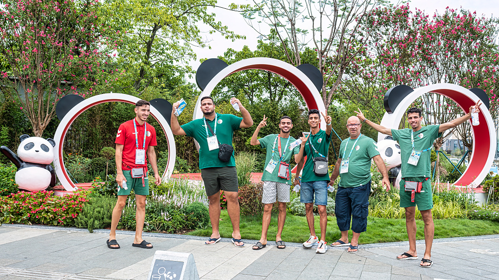 Athletes and coaching staff pose for a photo in front of a set of panda-themed sculptures at the Summer World University Games Village in Chengdu, Sichuan Province, July 31, 2023. /CFP