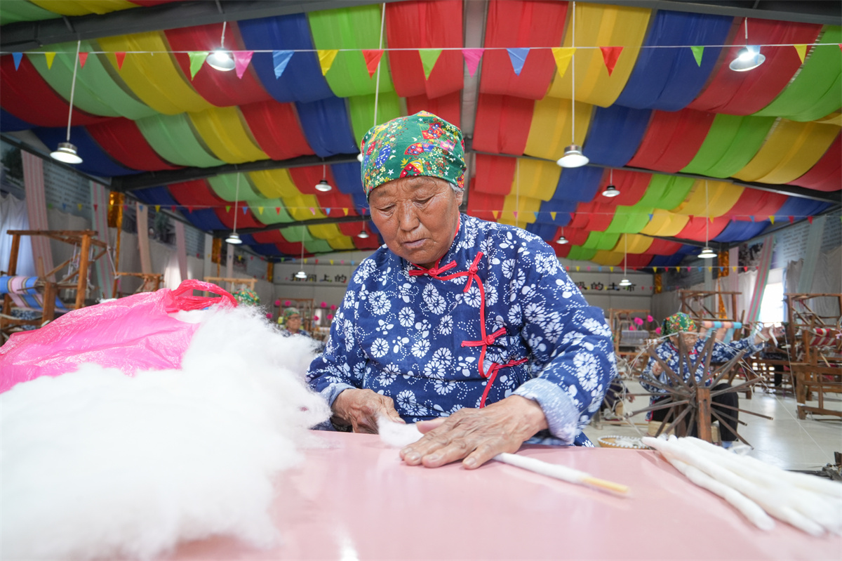 A woman is busy making Huichang cloth at a factory in Dongkaizhang Village, Yongji City, north China's Shanxi Province on May 18, 2023. /CNSPHOTO