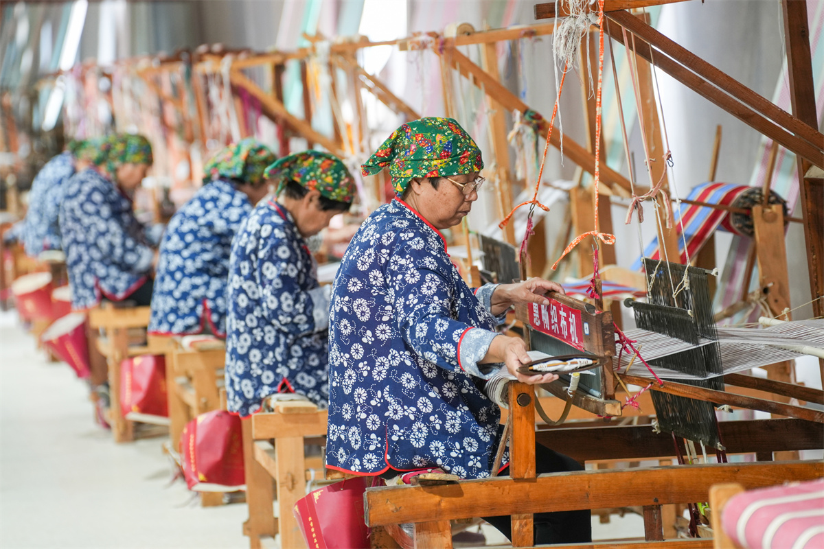 Women are busy weaving Huichang cloth at a factory in Dongkaizhang Village, Yongji City, north China's Shanxi Province on May 18, 2023. /CNSPHOTO