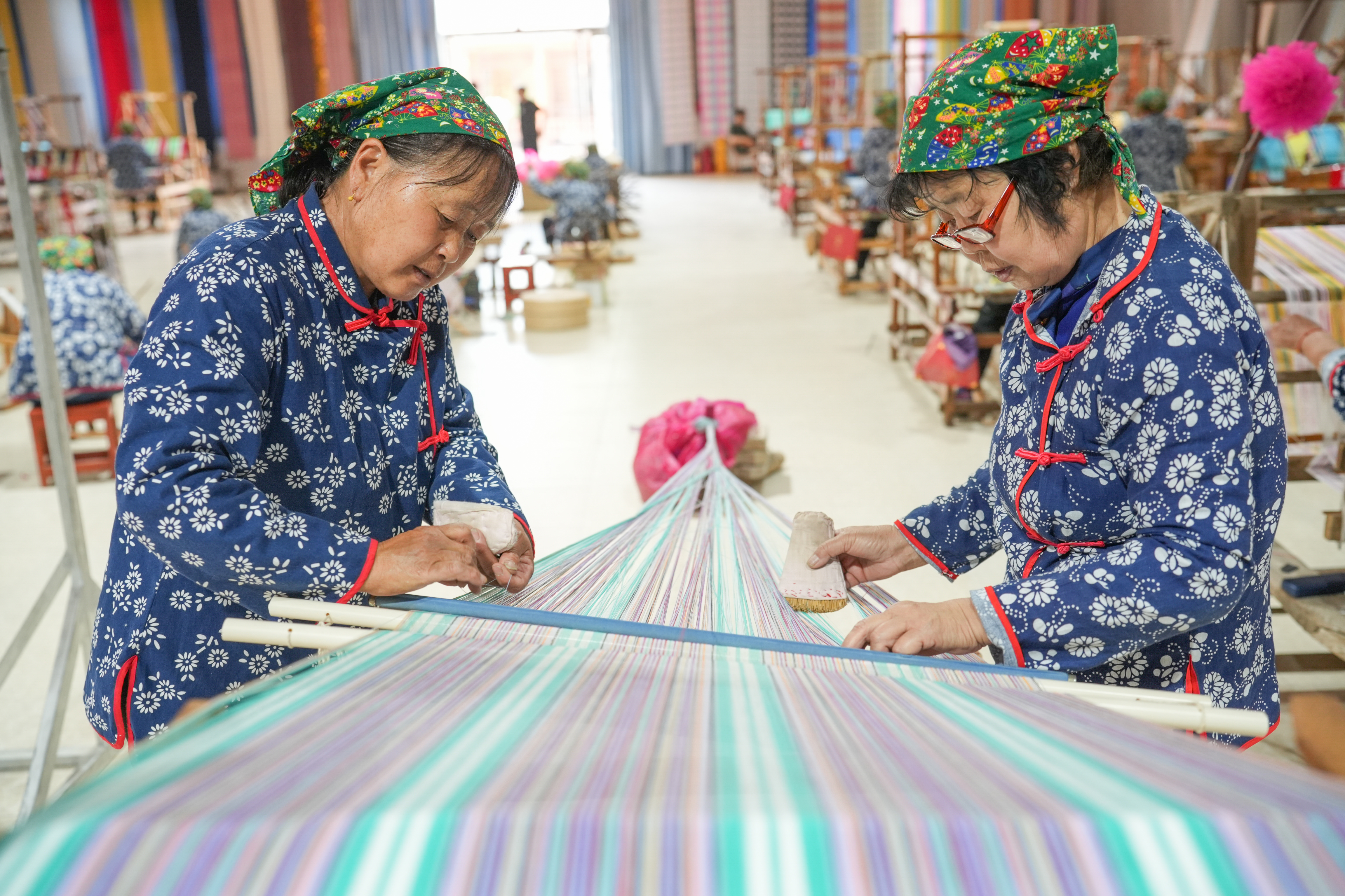 Two women weave Huichang cloth at a factory in Dongkaizhang Village, Yongji City, north China's Shanxi Province on May 18, 2023. /CNSPHOTO