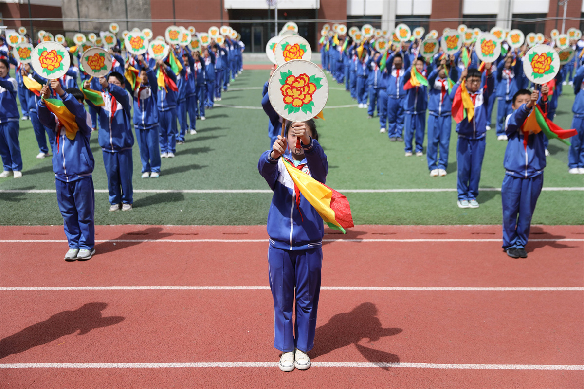 Students at a primary school in Chengde, Hebei Province practice the fan dance during daily exercise breaks between classes on May 6, 2023. / CNSPHOTO
