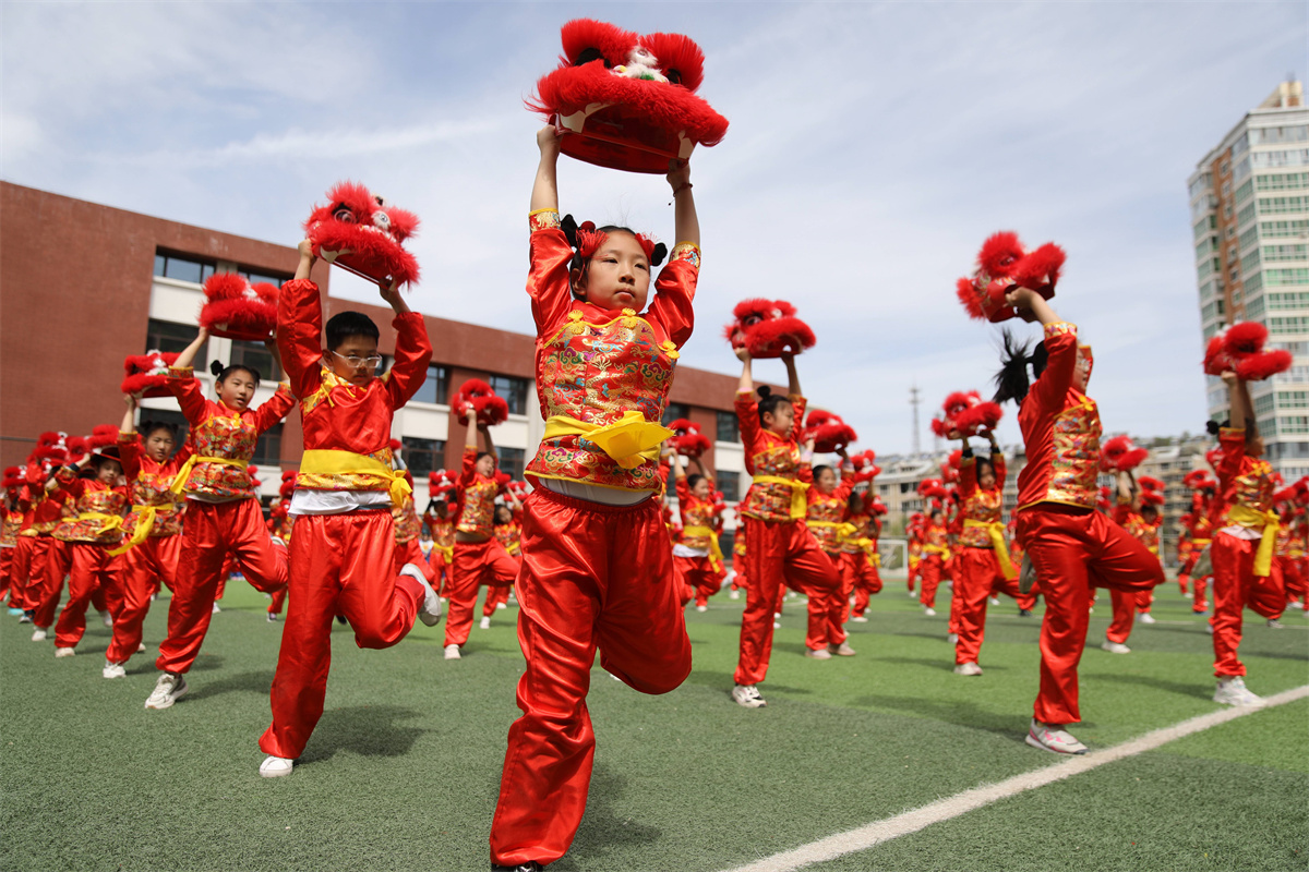 Students at a primary school in Chengde, Hebei Province practice lion dancing during daily exercise breaks between classes on May 6, 2023. / CNSPHOTO