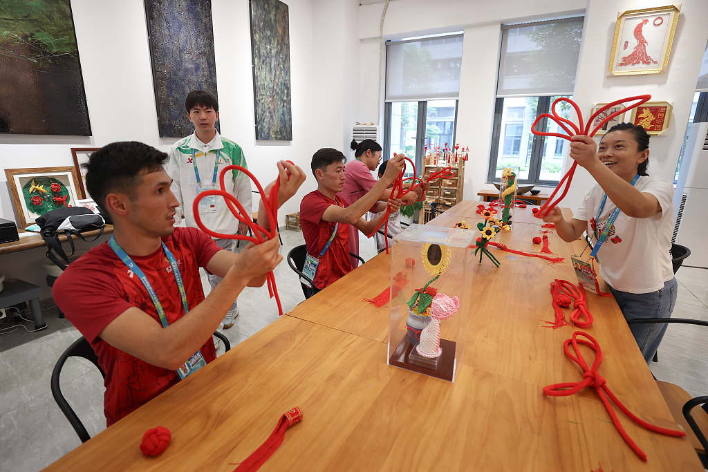 Photo taken on August 2, 2023 shows some foreign athletes experiencing China's intangible cultural heritage at the FISU Games Village in Chengdu, Sichuan Province. /CFP