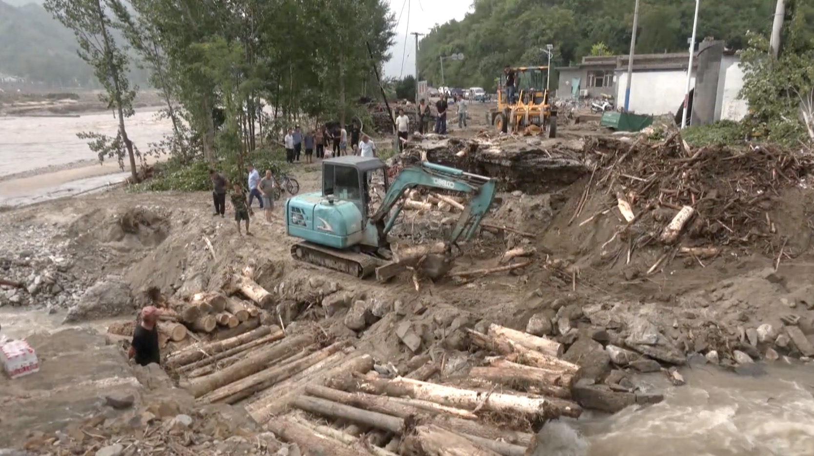 Excavators removed mud and debris from a damaged road. /CGTN