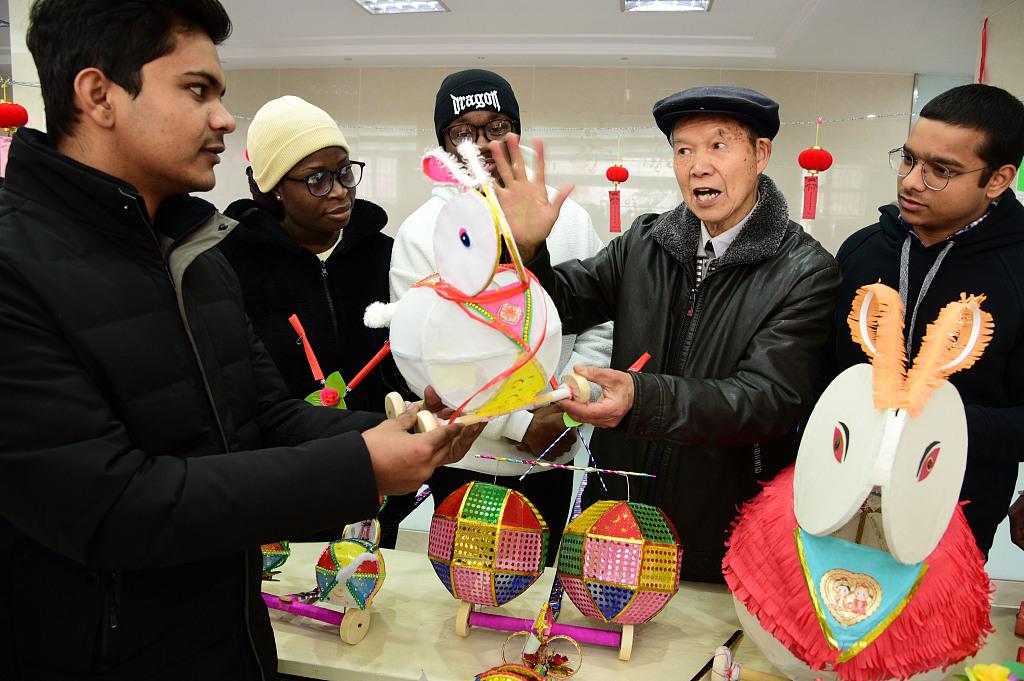 This file photo shows international students and residents enjoying the tradition of making lanterns and guessing lantern riddles in Zhenjiang, Jiangsu Province. /CFP