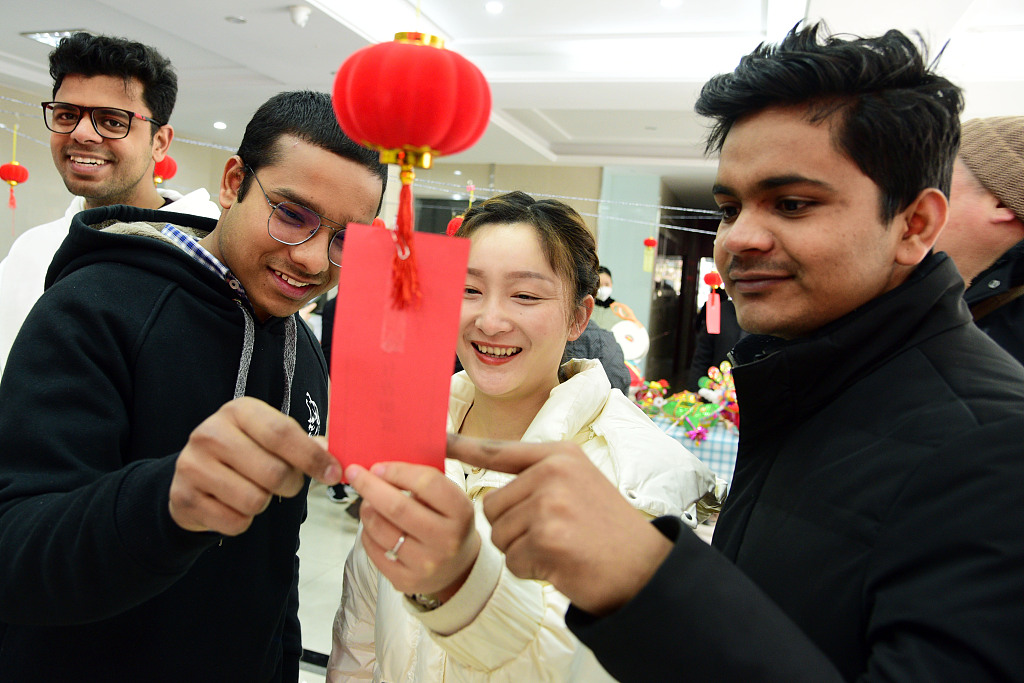 This file photo shows international students and residents enjoying the tradition of making lanterns and guessing lantern riddles in Zhenjiang, Jiangsu Province. /CFP