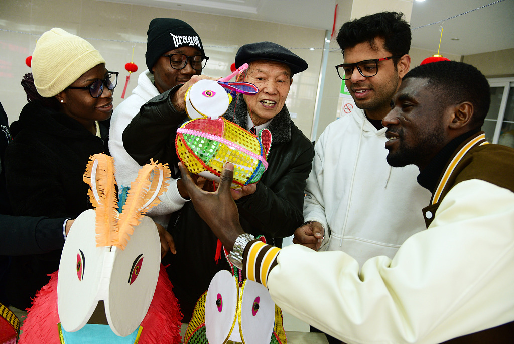 This file photo shows international students and residents enjoying the tradition of making lanterns and guessing lantern riddles in Zhenjiang, Jiangsu Province. /CFP