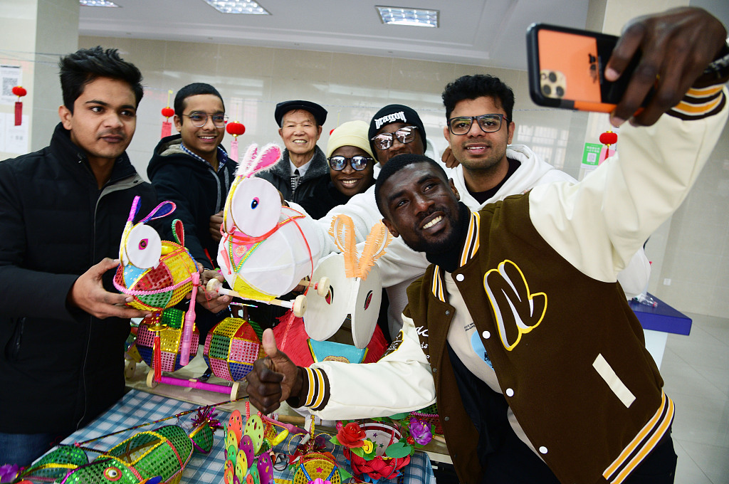 This file photo shows international students and residents enjoying the tradition of making lanterns and guessing lantern riddles in Zhenjiang, Jiangsu Province. /CFP