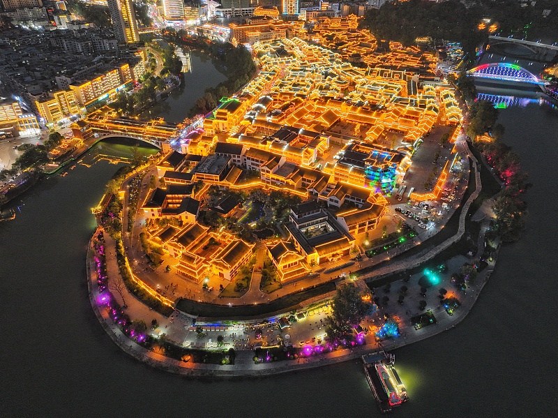 An aerial photo shows the Zhongnanmen Historical and Cultural Tourism and Leisure Block illuminated at night in Tongren City, Guizhou Province. /CFP