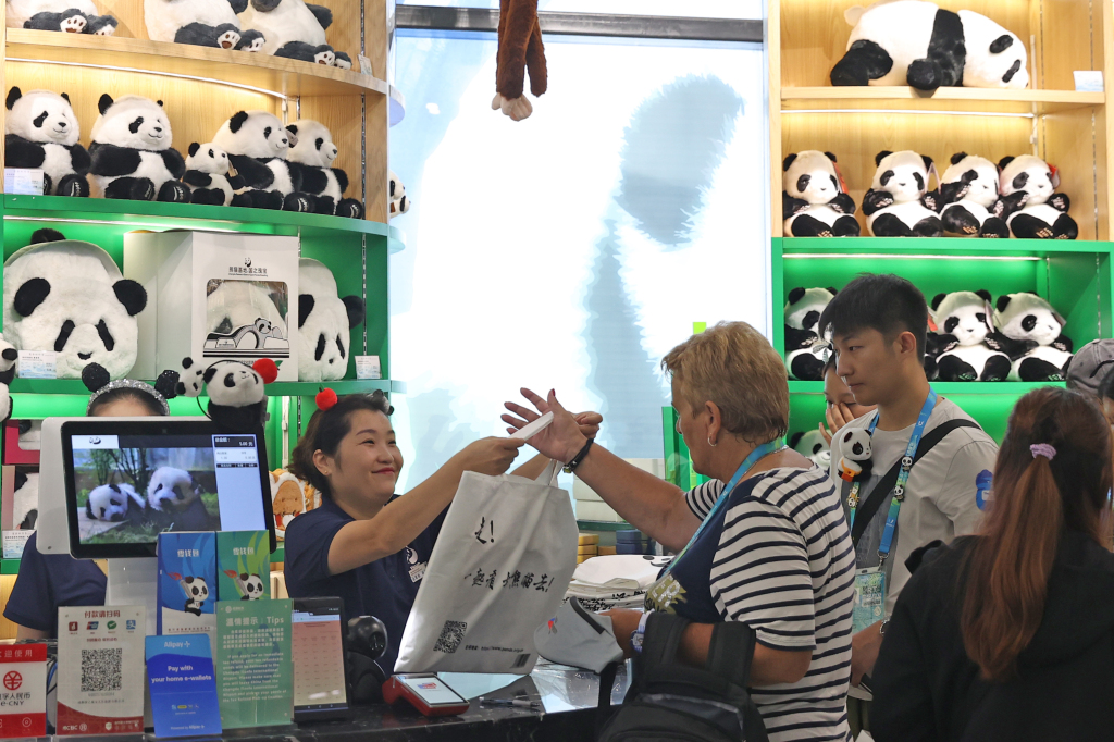 International participants of the 31st summer edition of the FISU World University Games select panda-themed souvenirs at the Chengdu Research Base of Giant Panda Breeding in southwest China's Sichuan Province, August 6, 2023. /CFP