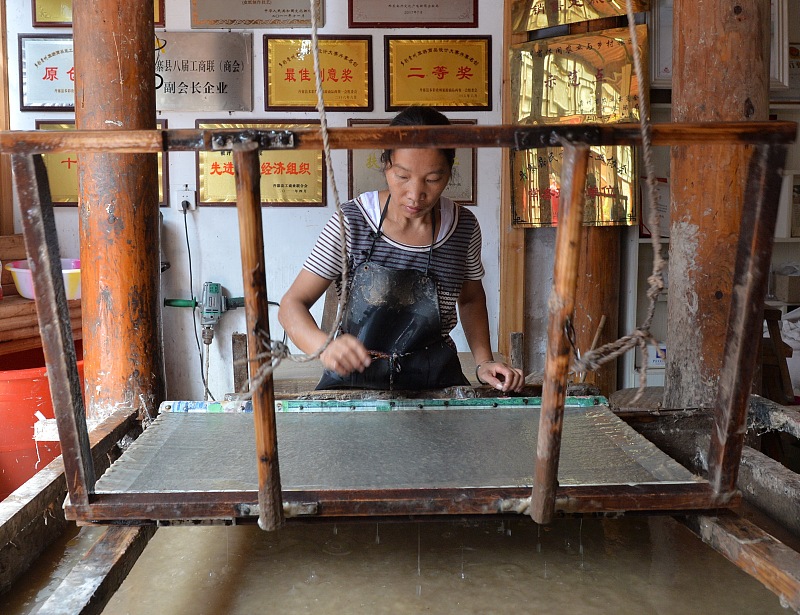 A woman practices traditional papermaking techniques in Danzhai County, Guizhou Province. /CFP