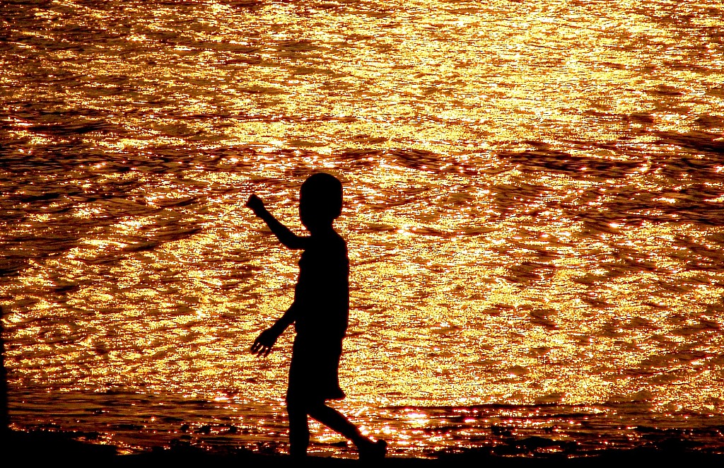 A file photo shows a child walking along a river bank to cool down on the first day of Liqiu in Zhengzhou, Henan Province, China. /VCG