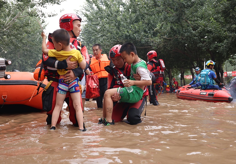 Rescue workers transport children out of flood-hit areas in Zhuozhou, Baoding City, north China's Hebei Province, August 3, 2023. /CFP