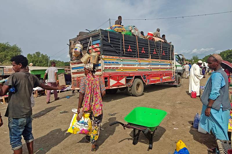 People wait to board a bus from Sudan's Qalabat border crossing with Ethiopia, July 31, 2023. /CFP