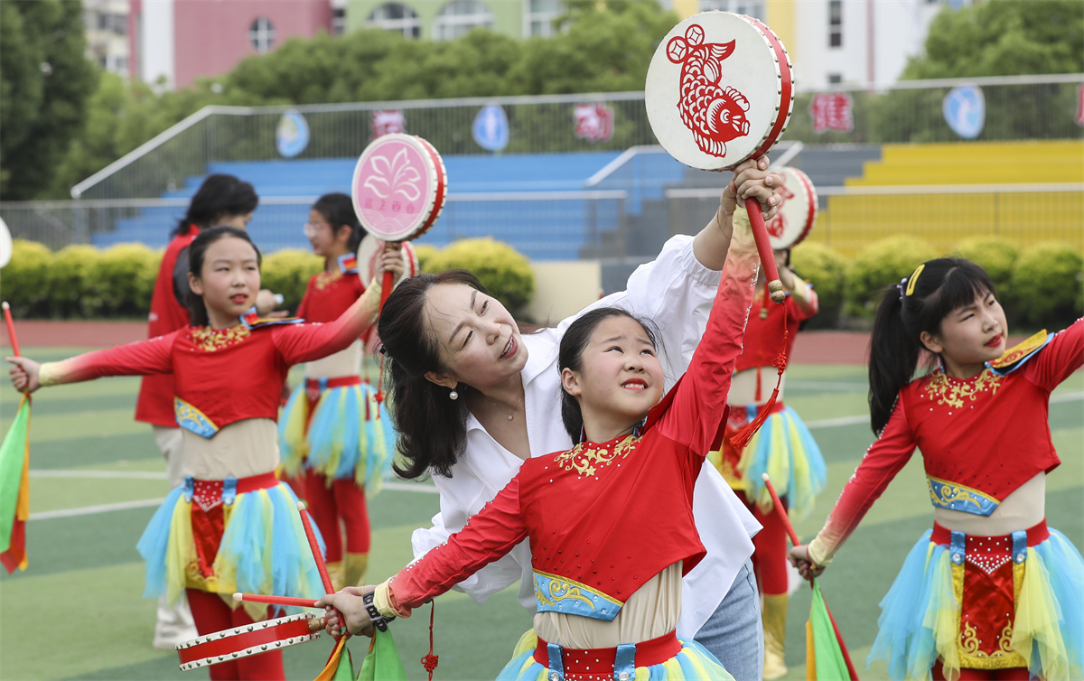 Students from a primary school in Huai'an, Jiangsu Province practice the fishing drum dance on May 26, 2023. /CNSPHOTO