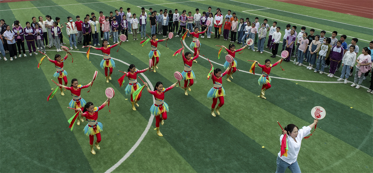 Students from a primary school in Huai'an, Jiangsu Province practice the fishing drum dance on May 26, 2023. /CNSPHOTO