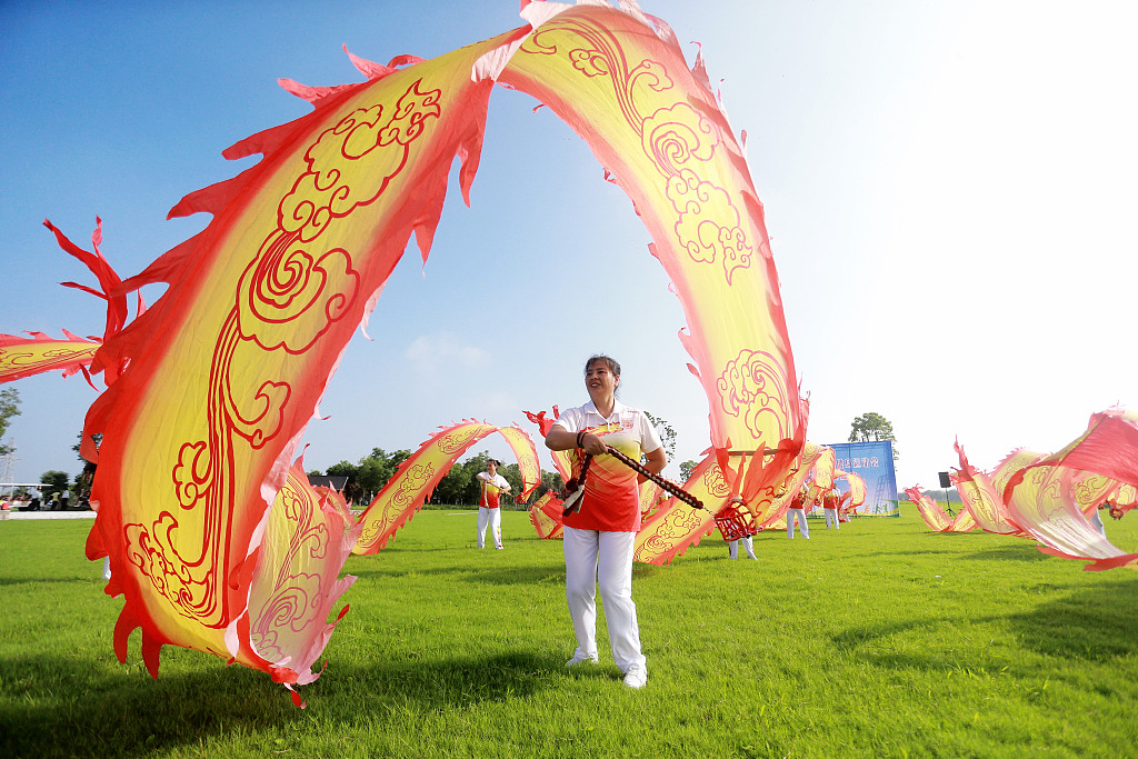 A woman plays with a giant ribbon as a leisure activity in Yangzhou, east China's Jiangsu Province, August 8, 2023. /CFP