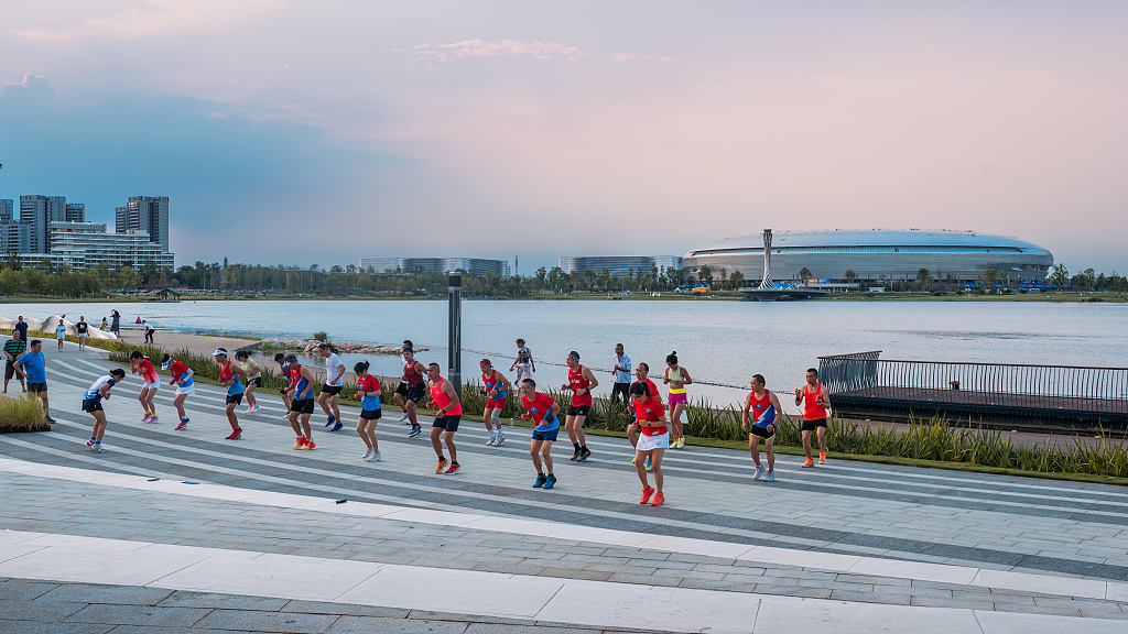 Runners warm up around the lake in Chengdu, China, August 2, 2023. /CFP
