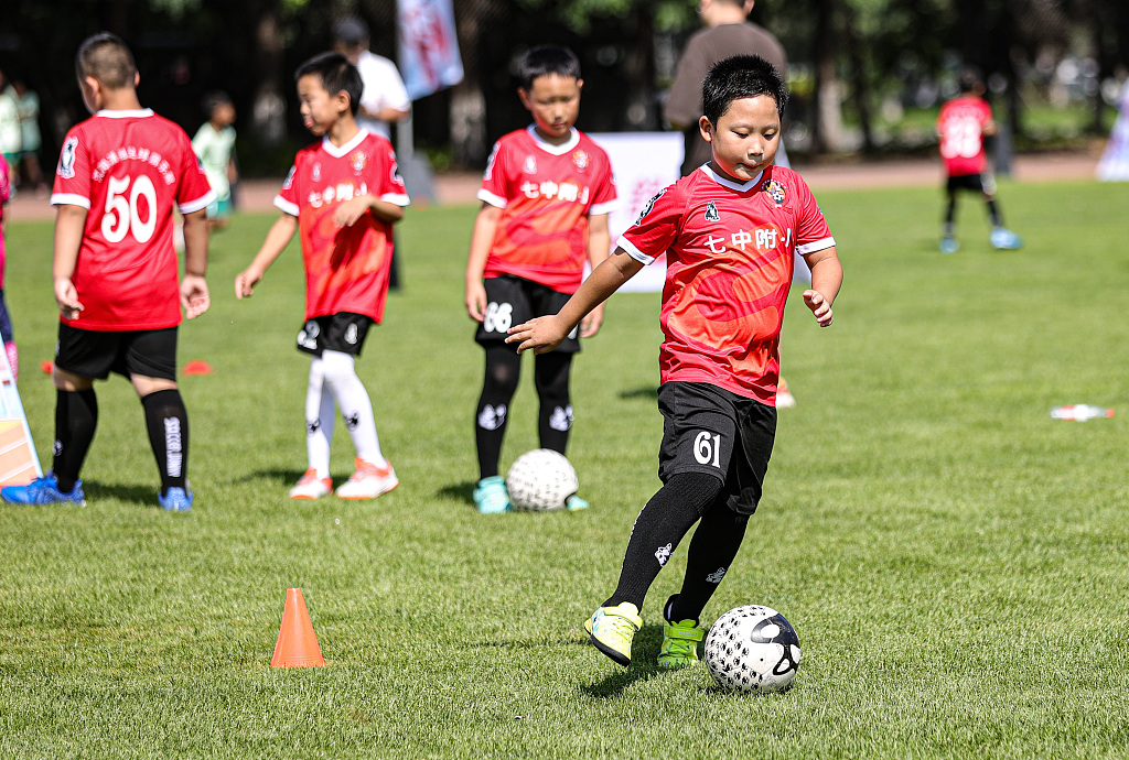 Boys warm up prior to their football match in Shenyang, northeast China's Liaoning Province, August 8, 2023. /CFP 