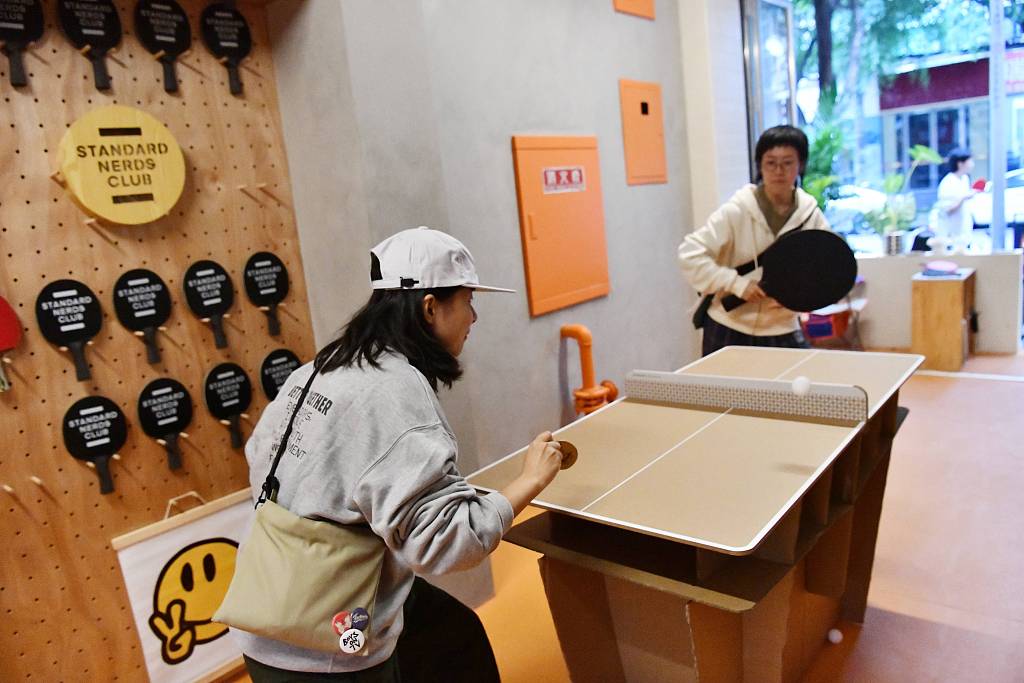 People play a fun table tennis game with different sizes of paddles in Chengdu, China, October 7, 2022. /CFP 