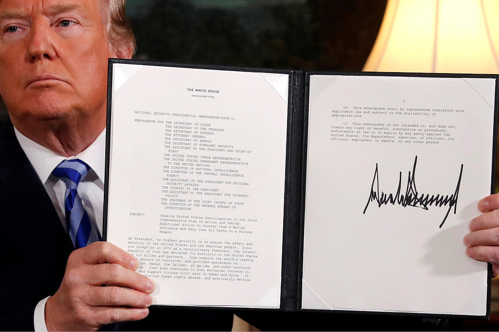Former U.S. President Donald Trump holds up a proclamation declaring his intention to withdraw from the JCPOA after signing it in the Diplomatic Room at the White House in Washington, D.C., U.S., May 8, 2018. /VCG