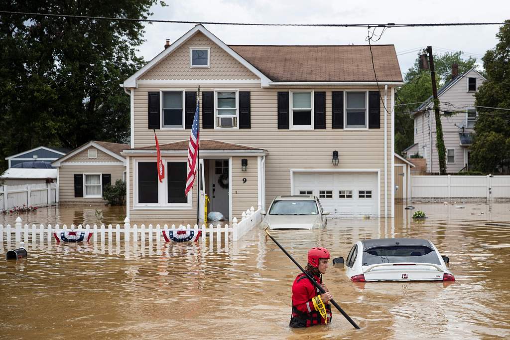 A New Market Volunteer Fire Company rescue crew member wades through high waters following a flash flood, as Tropical Storm Henri makes landfall, in Helmetta, New Jersey, on August 22, 2021. /CFP