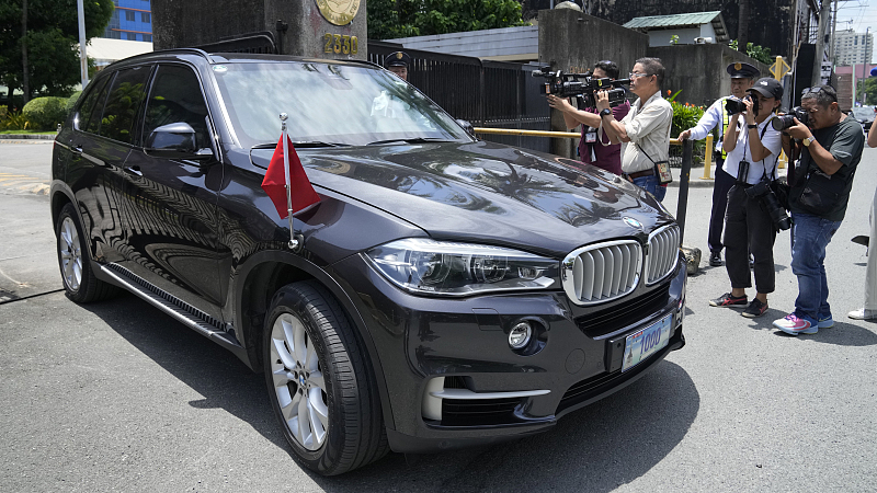 Journalists take pictures of a car with diplomatic plates and Chinese flag leaving the Philippine Department of Foreign Affairs in Manila, Philippines, August 7, 2023. /CFP