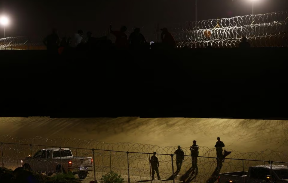 Members of the Texas National Guard stand guard at the border, as migrants gather with the intention to request asylum in the United States, after rumors spread that it would allow them to enter the U.S., according to local media, Ciudad Juarez, Mexico, August 7, 2023. /Reuters 