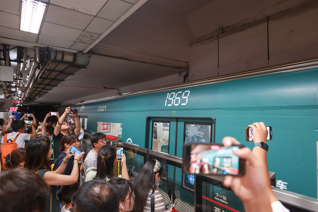 This photo taken on August 8, 2023 shows passengers taking pictures of the exterior of the 