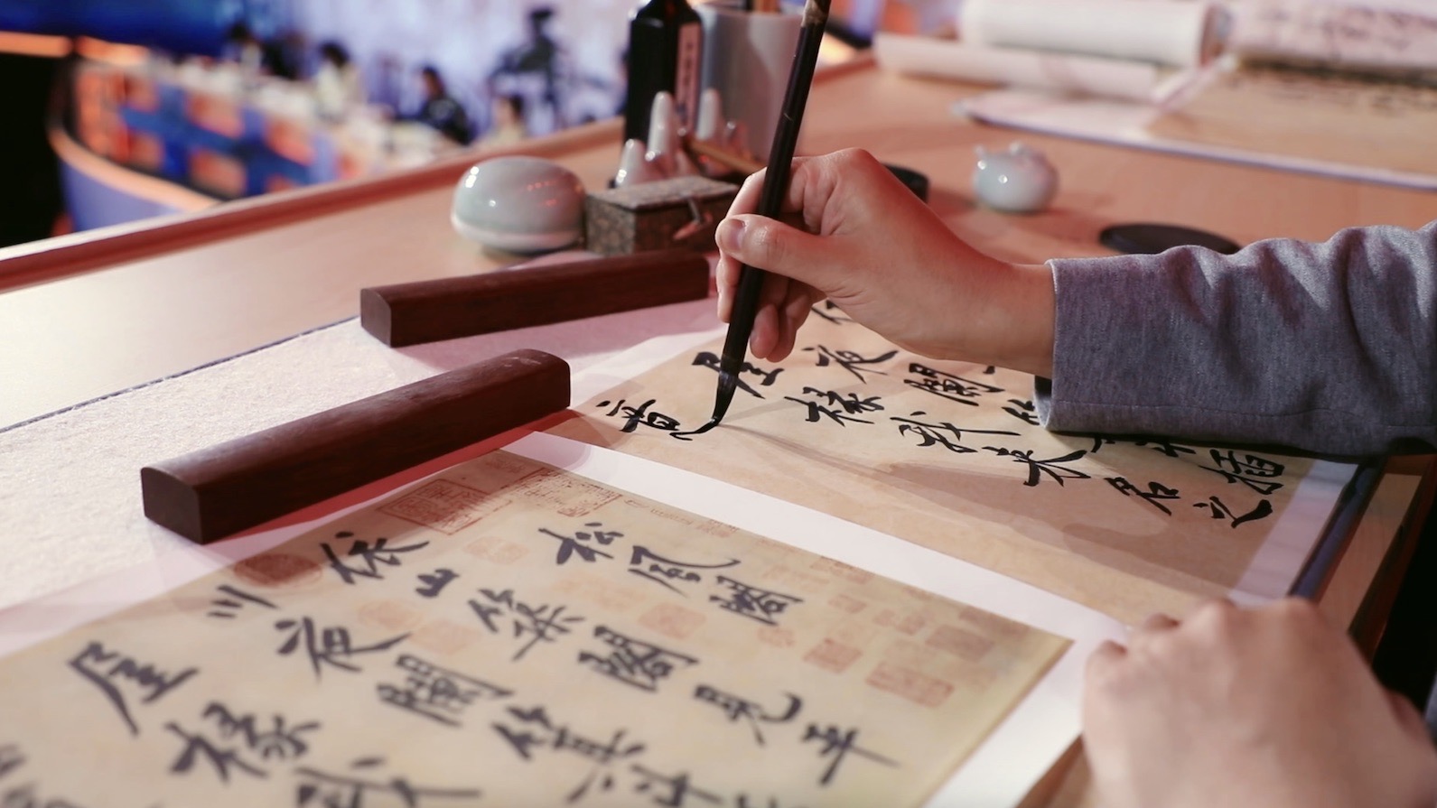 A calligraphy enthusiast practices Huang Tingjian's calligraphy work. /CGTN