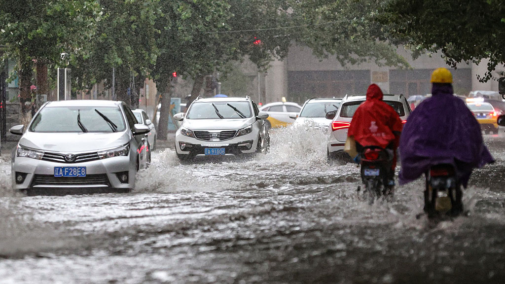 Residents travel under heavy rainfall, Shenyang City, northeast China's Liaoning Province, August 12, 2023. /CFP