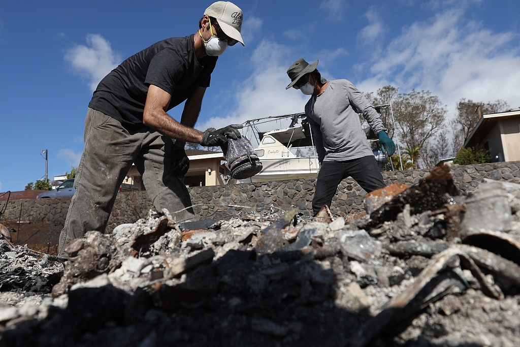 Brook Cretton (L) and Spencer Kim (R) sift through the rubble of a home that was destroyed by wildfire in Kula, Hawaii, August 12, 2023. /CFP