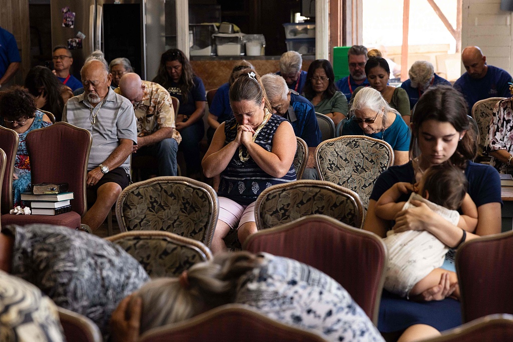 Survivors and churchgoers pray during a Sunday church service held by Pastor Brown of Lahaina's Grace Baptist Church, at Maui Coffee Attic in Wailuku, central Maui, Hawaii, August 13, 2023. /CFP