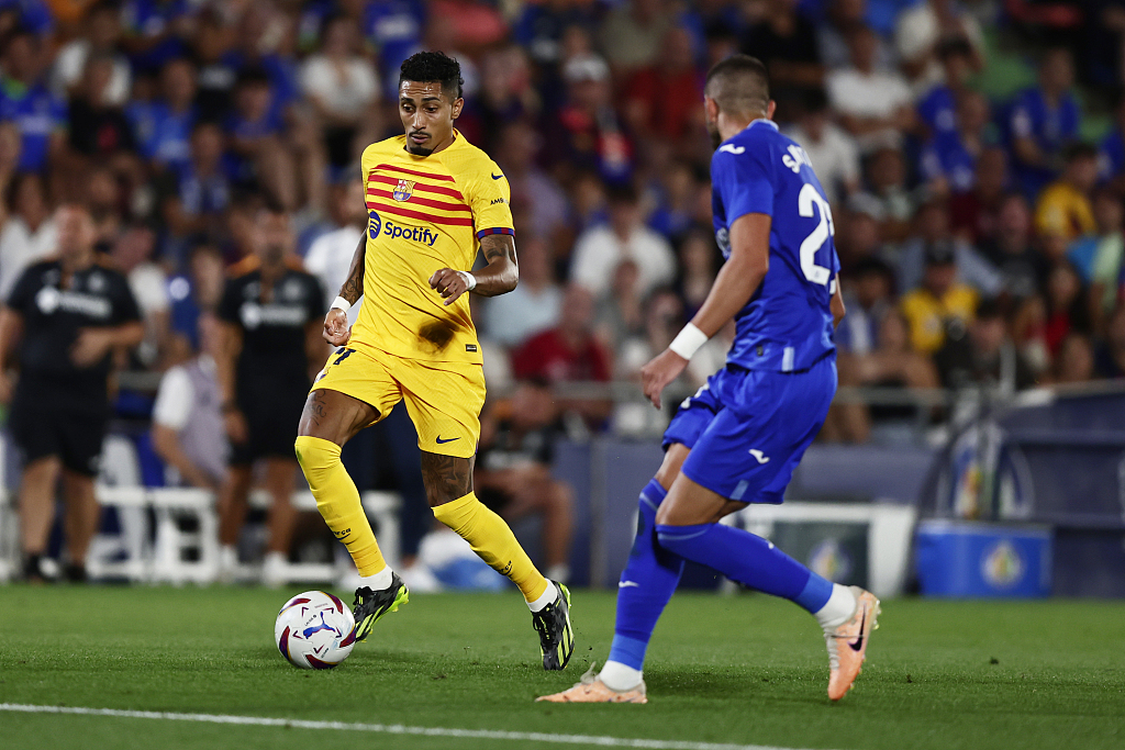 Barcelona's Raphinha (L) and Getafe's Stefan Mitrovic challenge for the ball during their Spanish La Liga clash at the Coliseum Alfonso Perez stadium in Getafe, Spain, August 13, 2023. /CFP