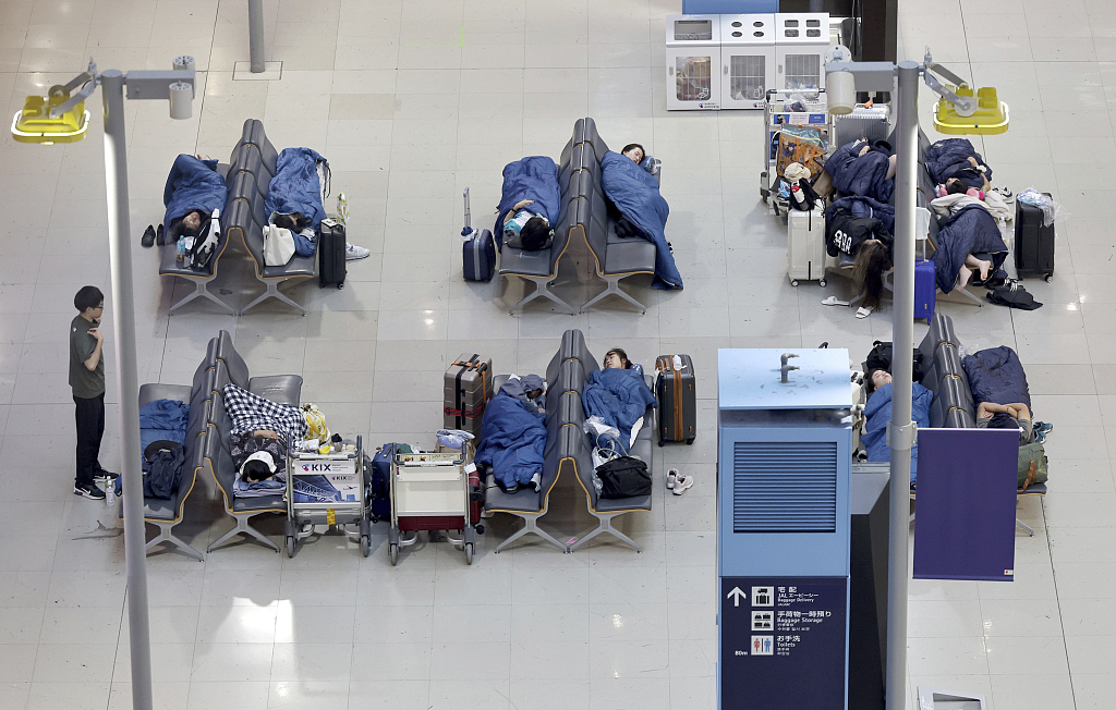 Passengers sleep at the airport while Typhoon No.7 (Lan) lands on the main island of Japan at Kansai International Airport in Osaka, August 15, 2023. /CFP