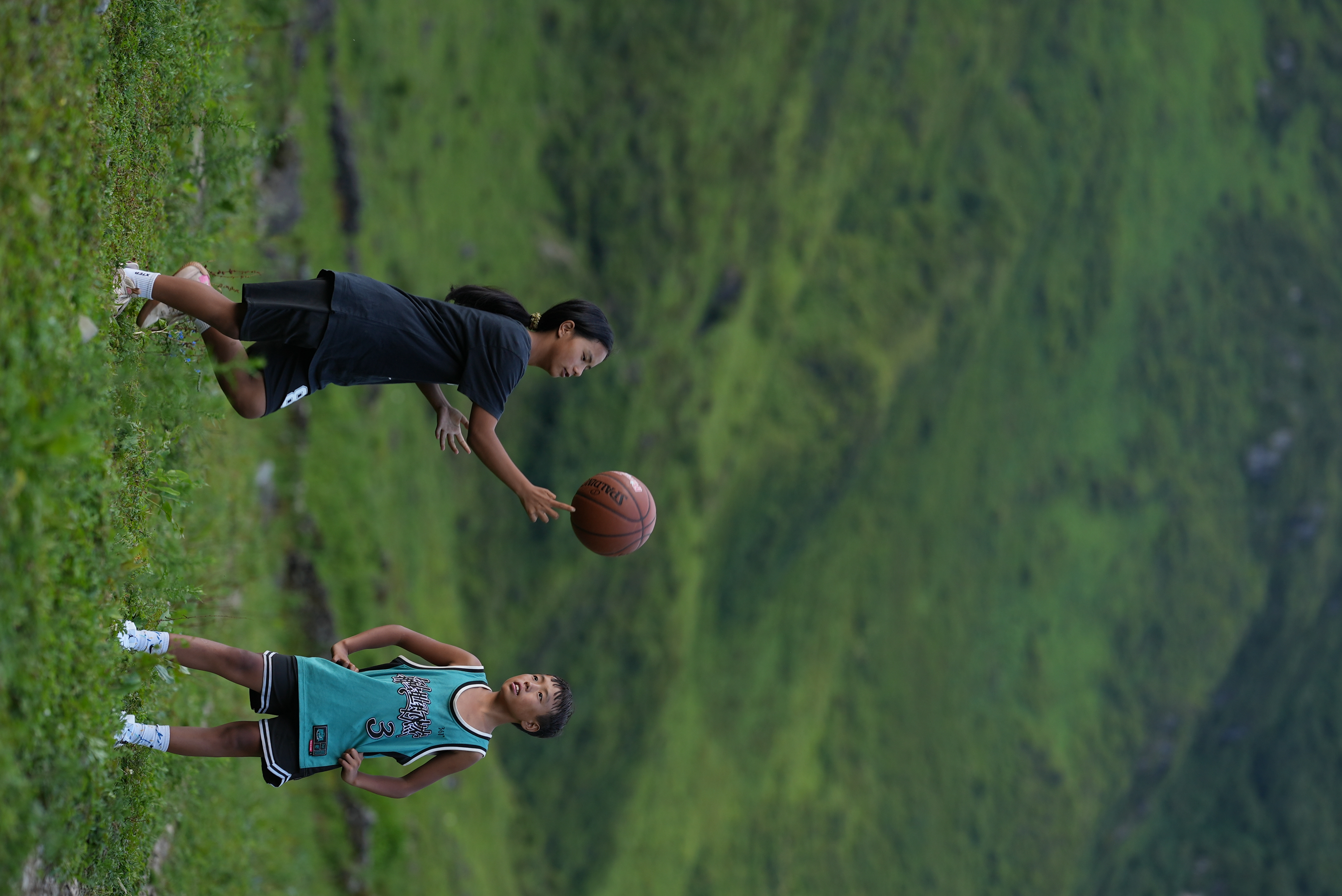 This undated photo shows kids pairing basketball finger spinning skills in Liangshan Yi Autonomous Prefecture, southwest China's Sichuan Province. /CGTN