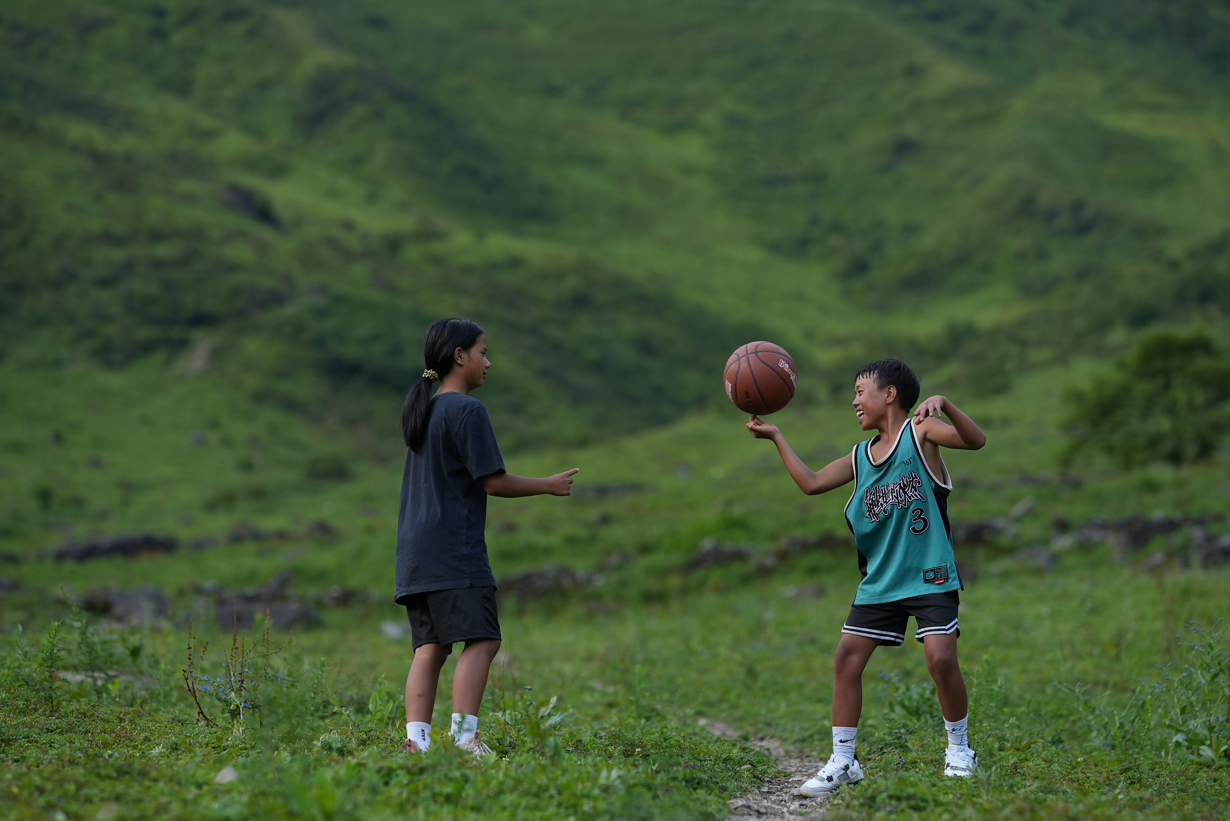 This undated photo shows kids pairing basketball finger spinning skills in Liangshan Yi Autonomous Prefecture, southwest China's Sichuan Province. /CGTN