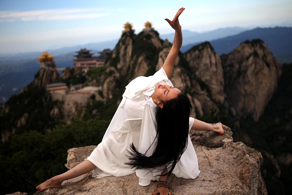 A photo shows an enthusiast practicing yoga on a cliff in Luoyang, Henan Province, China. /CFP