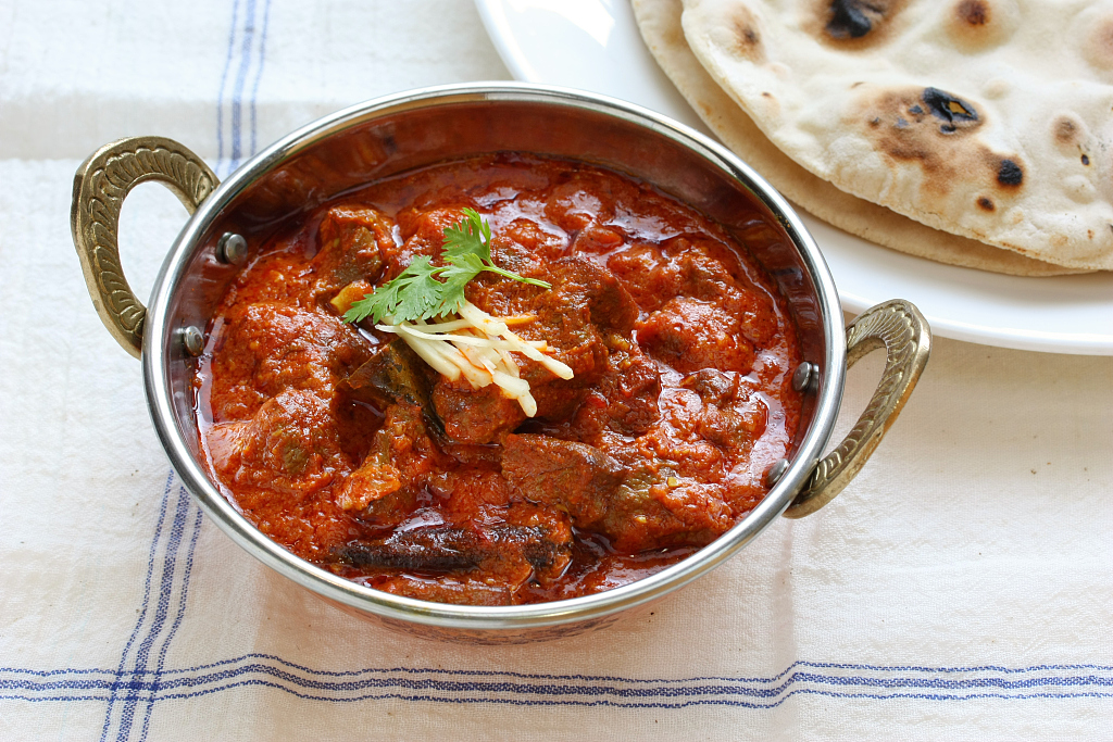 An Indian beef curry dish is served with naan bread. /CFP