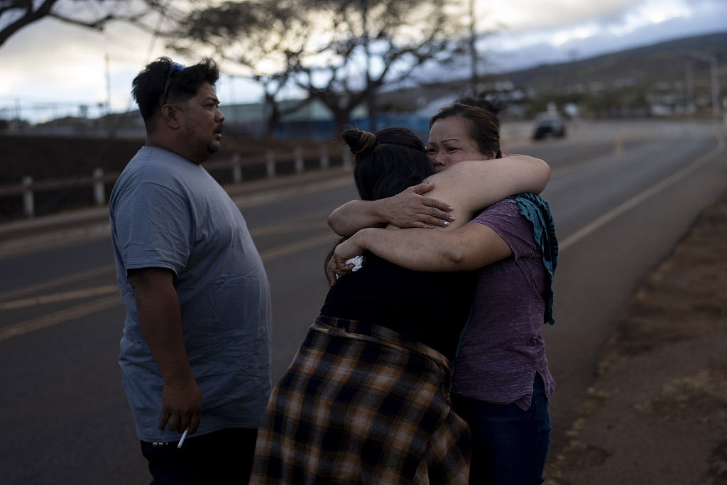 Nora Bulosan (R) and Hannah Tomas, Lahaina residents who survived the fire that devastated the town, comfort each other as they gather in hopes to get access to their home in Lahaina, Hawaii, on August 16, 2023. /CFP 