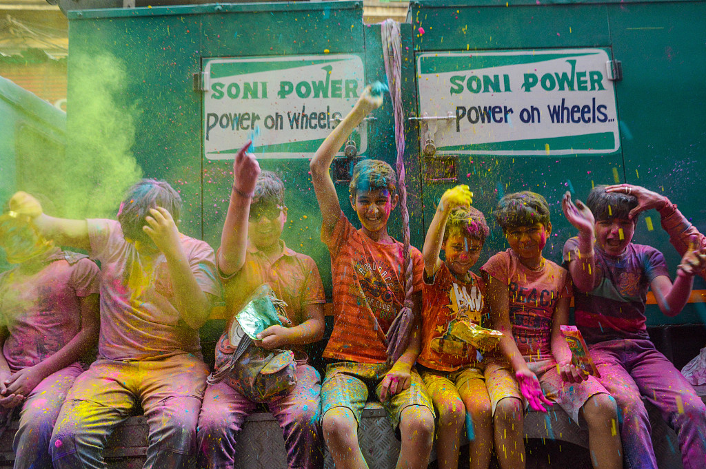 Children celebrate Holi in Kolkata, India, on March 5, 2023, with their bodies and clothes stained with colored powder. /CFP