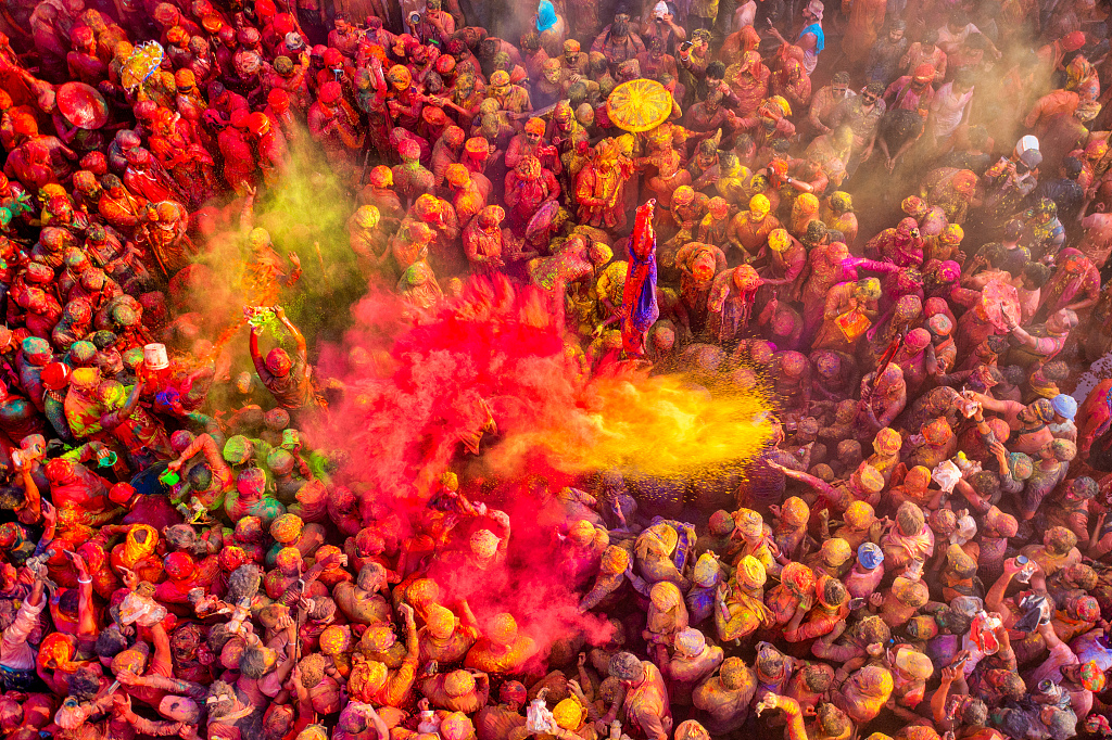 Thousands of people gather on streets, throwing handfuls of powder of various colors into the air to celebrate Holi on March 3, 2023, in Uttar Pradesh, India. /CFP