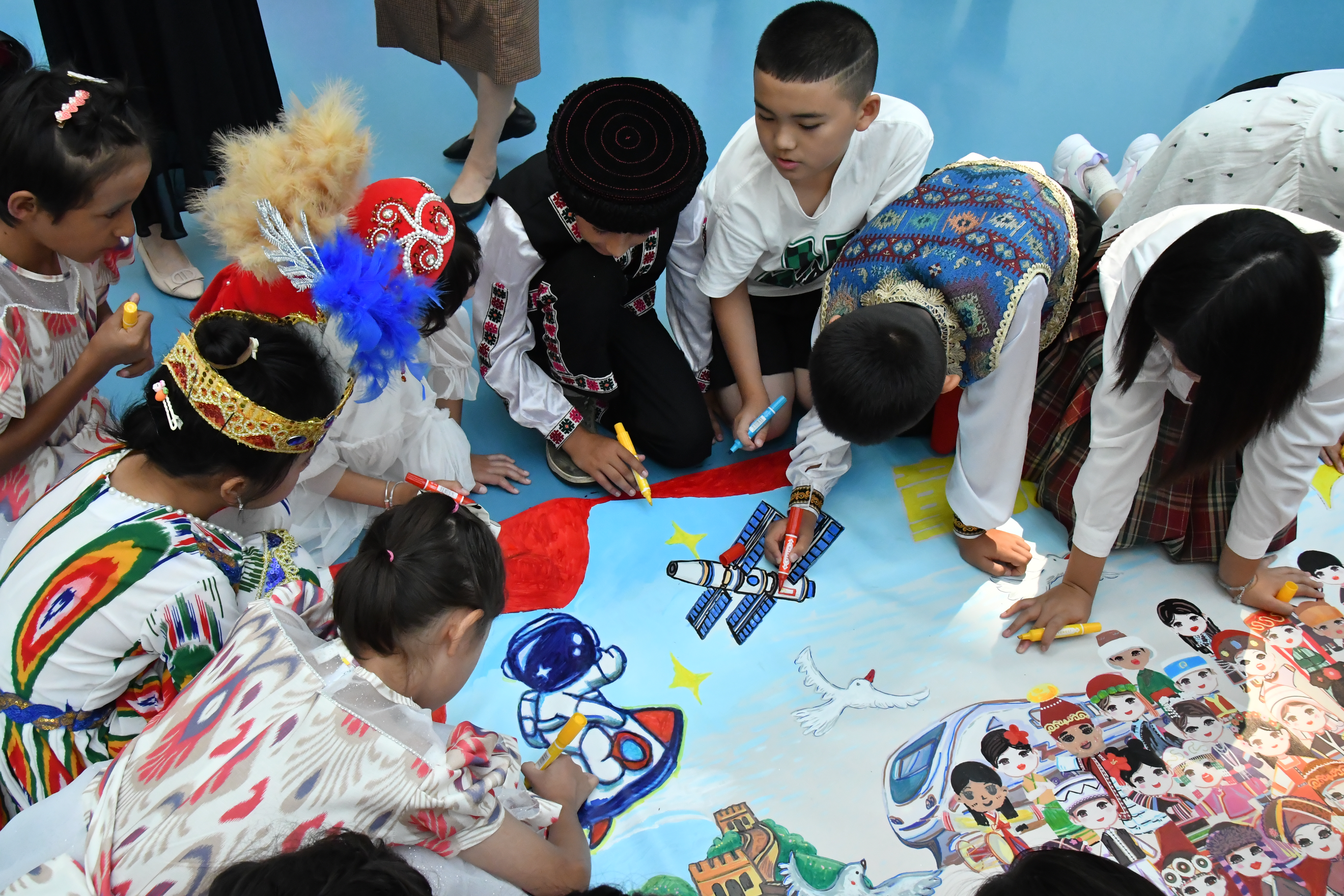 A total of 60 children from Xinjiang, Beijing and Guangdong work on art at an exhibition event in Beijing. /Yin Limei