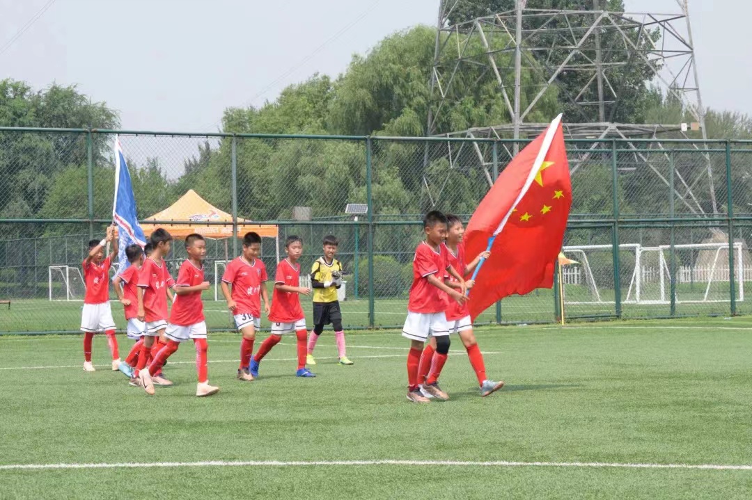 Young players of a Chinese team enter the pitch with holding the national flag in Shenyang, China. /Peace Cup
